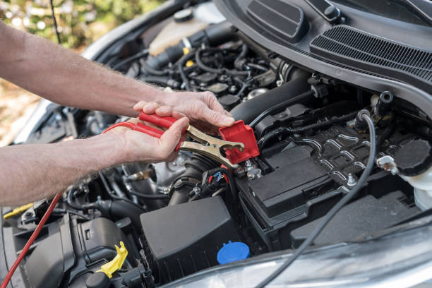 istock Hands of car mechanic using car battery jumper cable 693635190