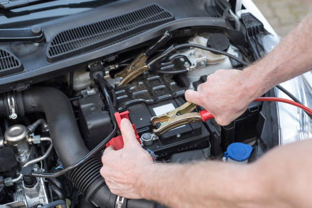 istock Hands of car mechanic using car battery jumper cable 693635562