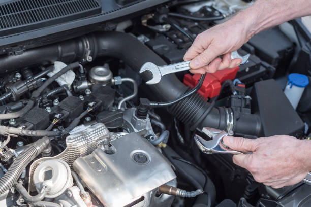 istock Hands of car mechanic working on car engine 693635818