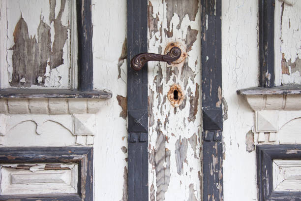 Detail of old wooden door covered with crumbling white paint