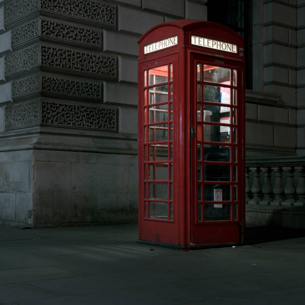 istock old red telephone booth at night in london 693637062