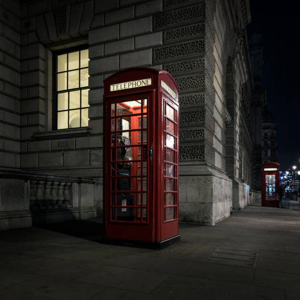 istock old red telephone booth at night in london 693637064