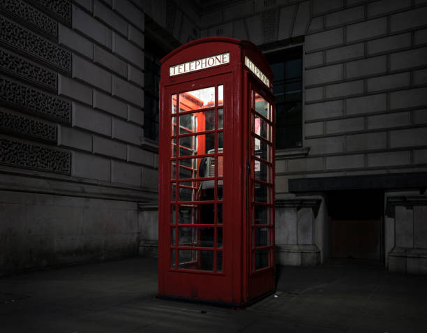 istock old red telephone booth at night in london 693637074
