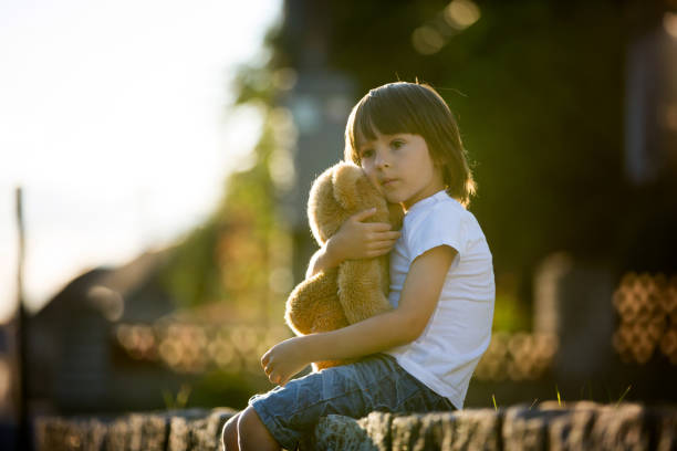 istock Sweet boy, playing with teddy bear on a small rural path on sunset, summertime 693647344