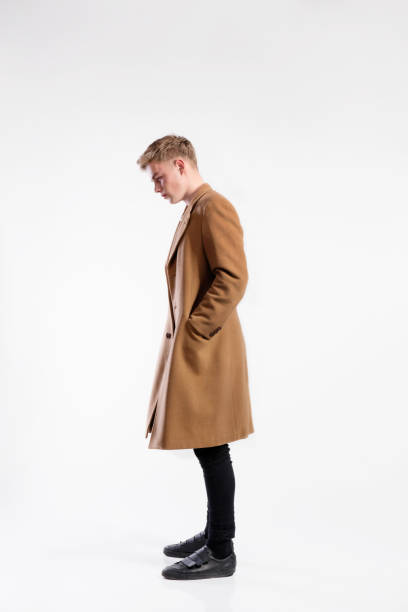 istock Young handsome hipster man in brown coat, studio shot. 693648630