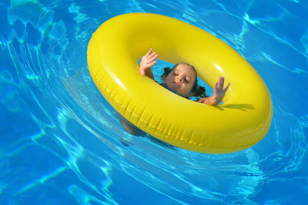 istock Adorable toddler relaxing in swimming pool 693653436
