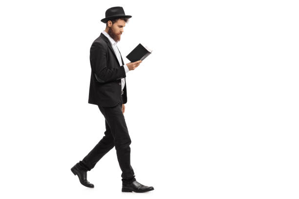 Religious man walking and reading a book Full length profile shot of a religious man walking and reading a book isolated on white background judaism photos stock pictures, royalty-free photos & images