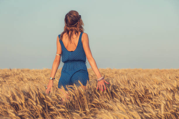 Young woman relaxing in the wheat field.