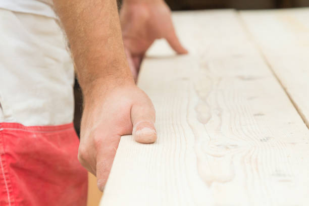 istock Carpenter holding a wood plank and concentrating for work. 693673752