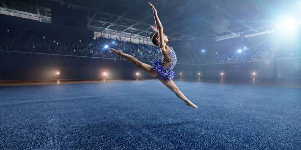 istock A small gymnast girl makes a leap on a large professional stage 693674604