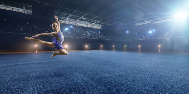 istock A small gymnast girl makes a leap on a large professional stage 693674650