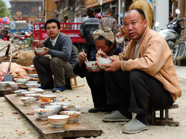 Residents of the Zhaoxing is a pretty Dong minority town eating on the High Street on the shared meal