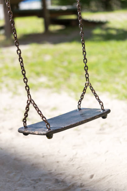 istock Empty wooden traditional swing on playground. 693682812