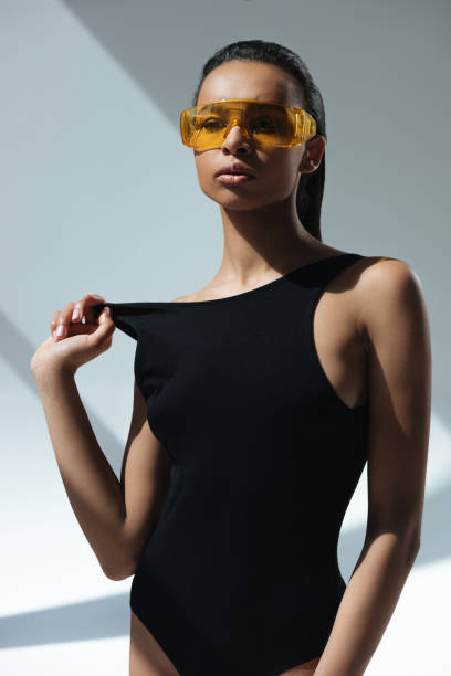 istock african american stylish model in black swimsuit and protective goggles posing on grey 693693028