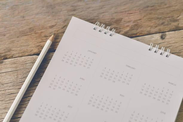 istock Blurred calendar on wood texture. 693695020