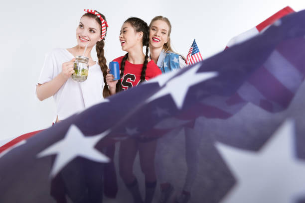 istock young women with american flag drinking beverages isolated on white 693695782