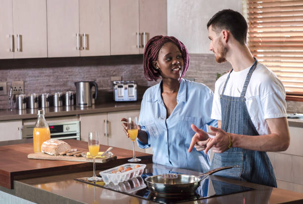 istock mixed race couple cooking breakfast in kitchen frying eggs 693696642