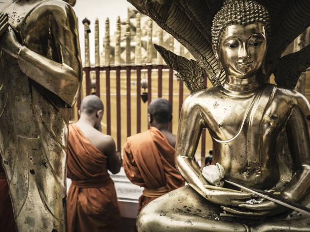 Buddhist monks praying at Wat Phra That Doi Suthep Chiang Mai Thailand during the celebration of Visakha Puja the anniversary of Buddha s birth and enlightenment . This temple in the outskirts of the city located on the top of a mountain that overlooks the city is a Theravadada wat was founded in 1383. the Gautama Buddha's shoulder bone is supposed to be housed here as a relic.