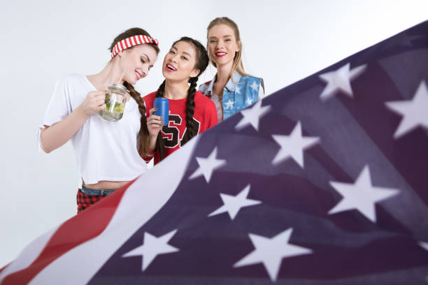 istock smiling girls with american flag drinking beverages isolated on white 693698906