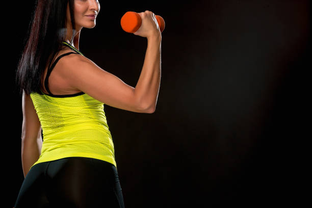 istock The woman training against black studio with red dumbbells 693708076