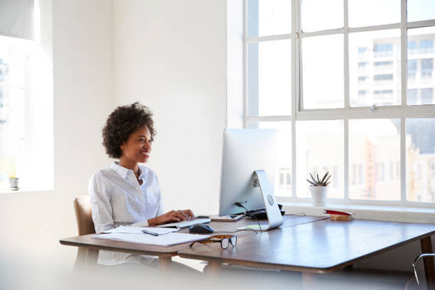 istock Young black woman working at computer in an office 693722542