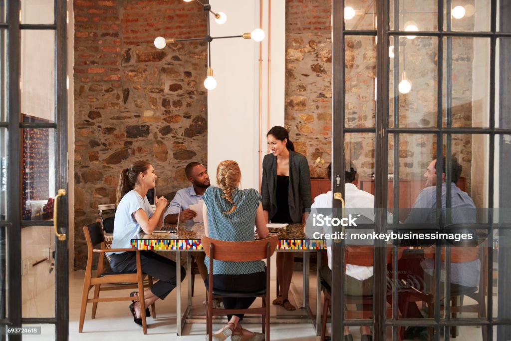 Il capo donna si rivolge al team aziendale in una sala riunioni - Foto stock royalty-free di Riunione