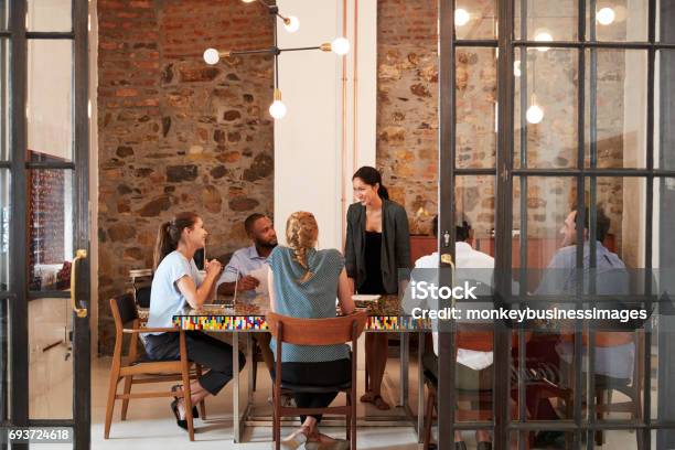 Female Boss Addressing Business Team In A Meeting Room Stock Photo - Download Image Now