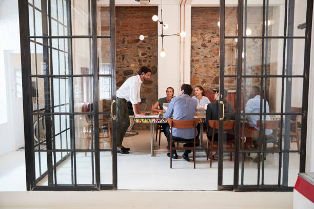 istock Young man managing a team meeting in a boardroom 693726078