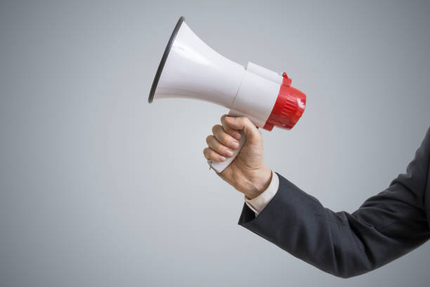 istock Announcement concept. Hand holds megaphone. 693728736