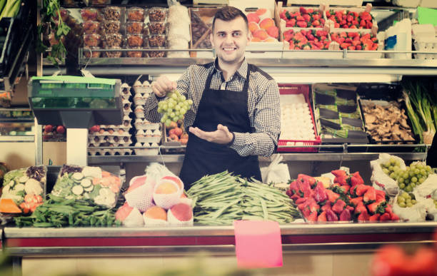 istock Man seller is weighing grapes 693744462