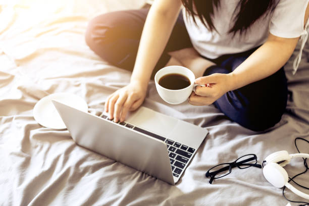 istock Woman working on a laptop in bed 693744896