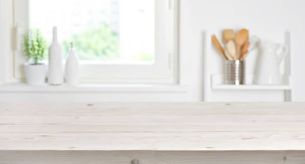 istock Wooden table on blurred background of kitchen window and shelves 693745670