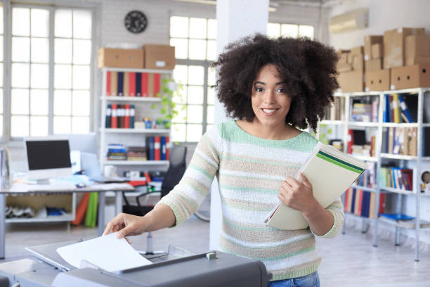 asistente sonriente con copia de la máquina en el trabajo - empleado de archivo fotografías e imágenes de stock