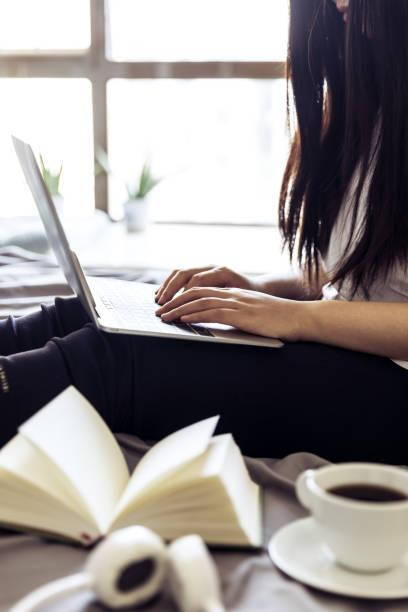 istock woman using laptop in bed 693751688
