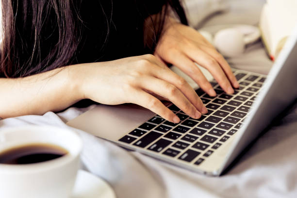 istock woman using laptop in bed 693754512