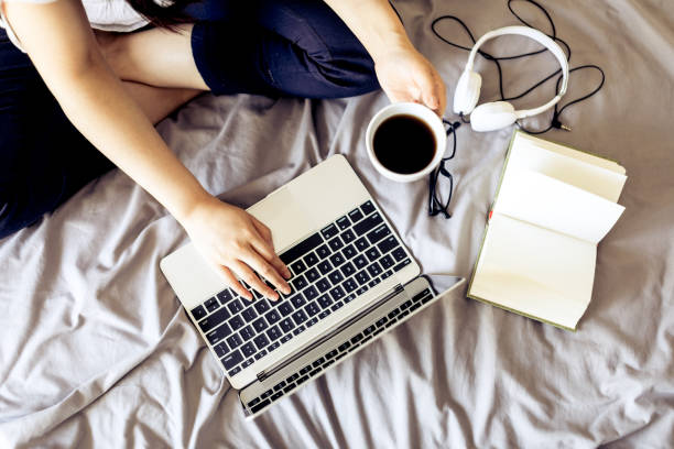 istock Woman typing laptop in bed 693757670