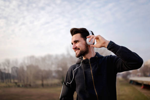 istock Morning exercise man taking break listening music 693762534