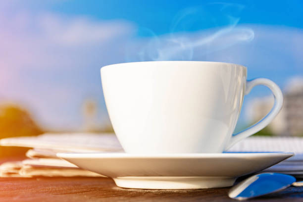 istock coffee cup clock and news paper on old wooden table 693771338