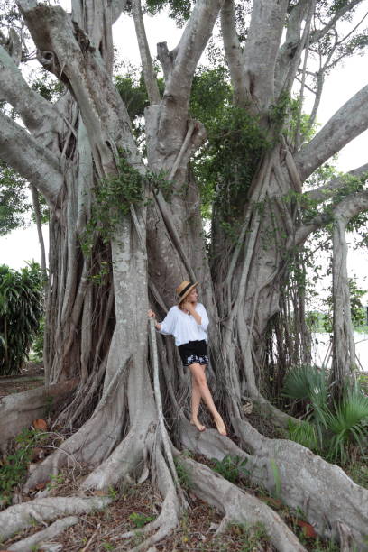 istock Young woman is standing on a tree roots. 693774442