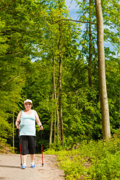 istock Senior woman practicing nordic walking in park 693778630