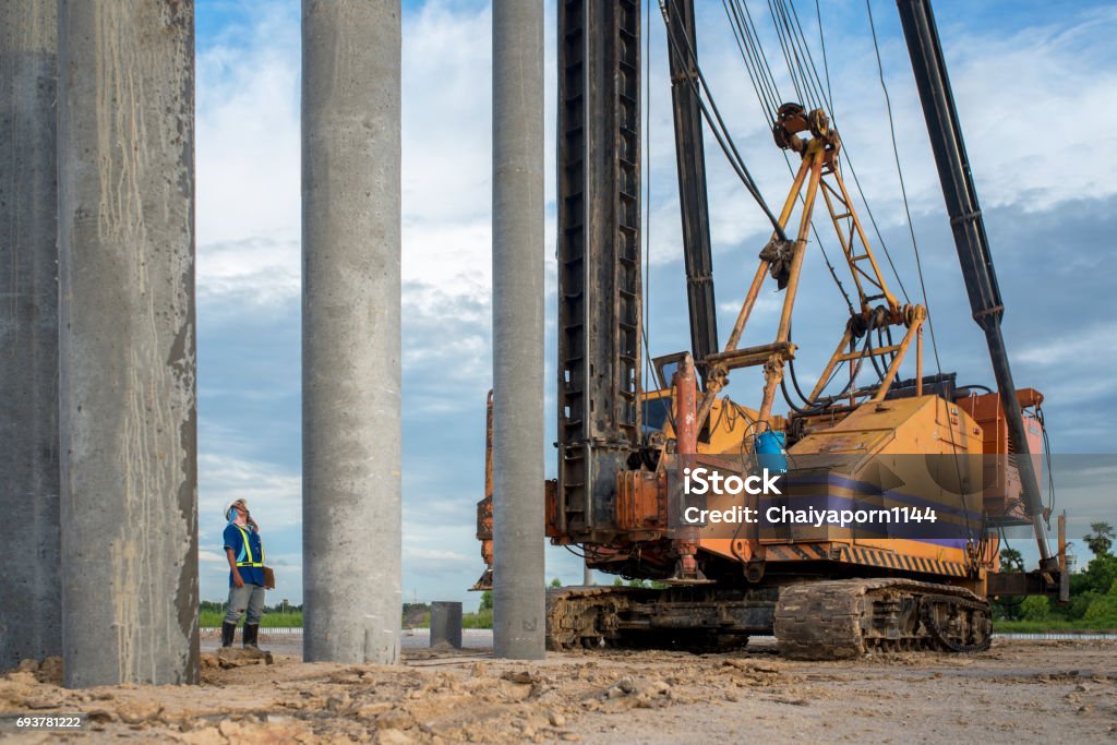 civil engineer inspection construction site concrete pile driving in safety uniform protection Heavy Stock Photo