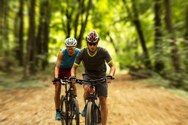 istock Two mountain bikers riding bike in the forest 693781792