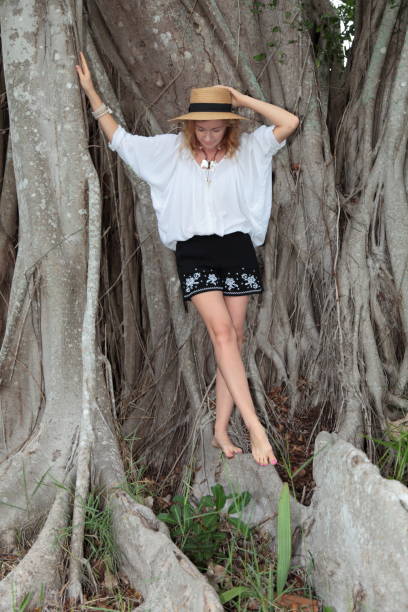 istock Young woman is standing on huge tree roots. 693781996