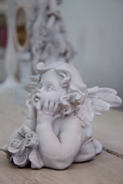 istock Retro statuette of an angel on a wooden table. 693787752