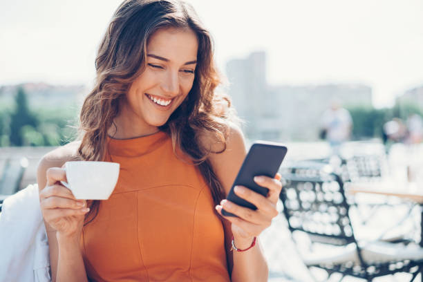 istock Beautiful young woman texting and drinking coffee 693791172