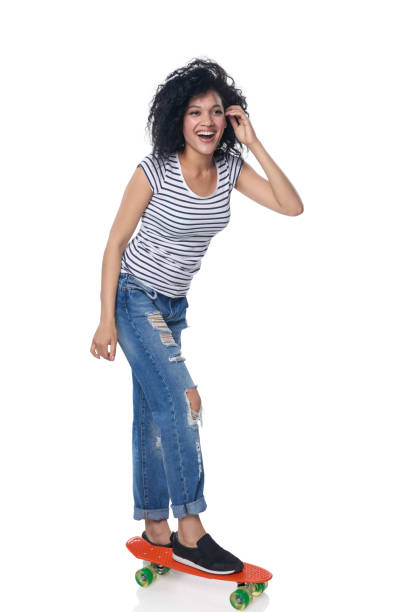 istock Happy female in distressed jeans with skateboard 693791410
