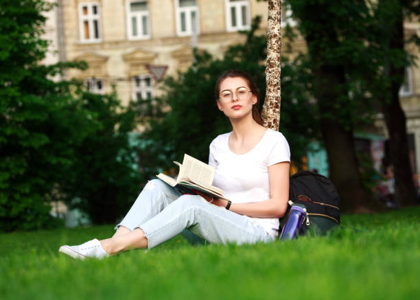 istock Girl student in city park with book 693794952