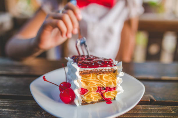 istock Girl Eating Cake in Cafe 693804014