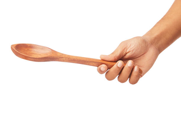 istock Male Hand holding wooden kitchen spoon 693809722