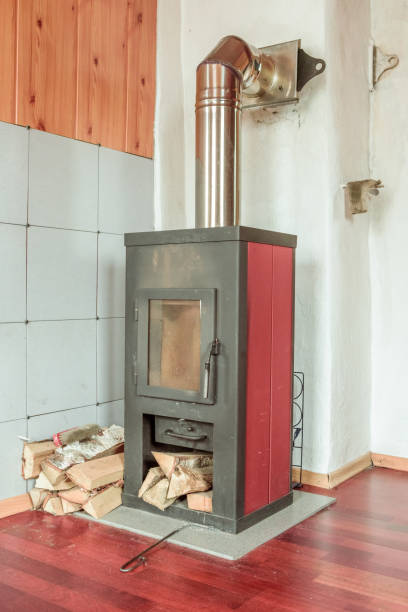 istock Traditional rustic metal stove and the stacked firewood 693812322